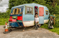 A vintage, uniquely decorated camper trailer parked outdoors